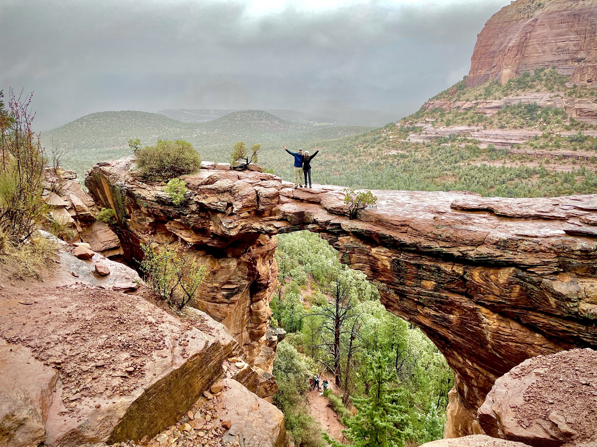 A couple standing on Devlis Arch in Sedona, Arizona